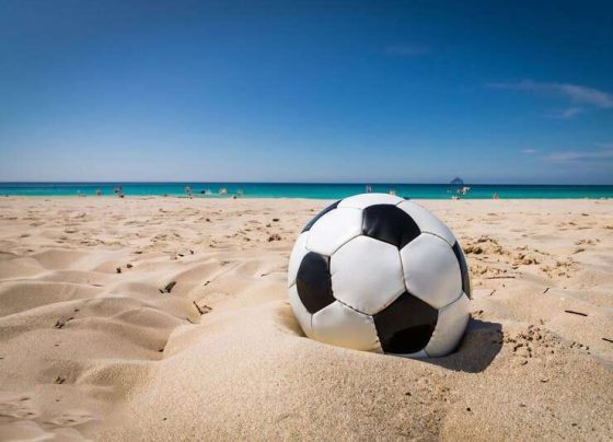 uma bola de futebol esta na areia de uma praia 888757 1190