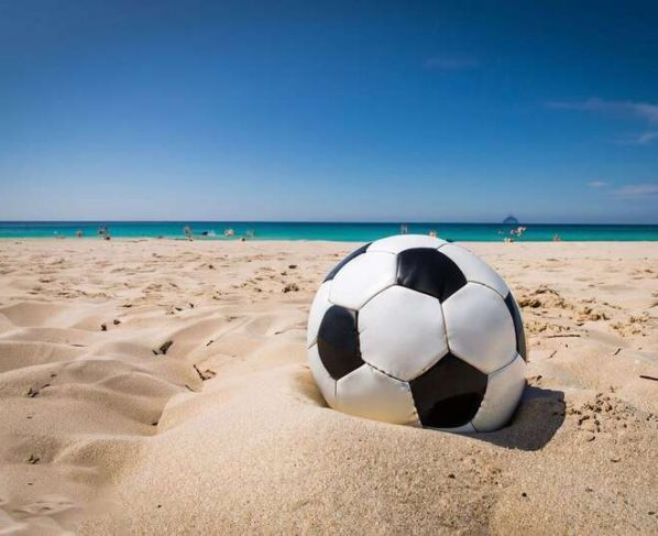 uma bola de futebol esta na areia de uma praia 888757 1190