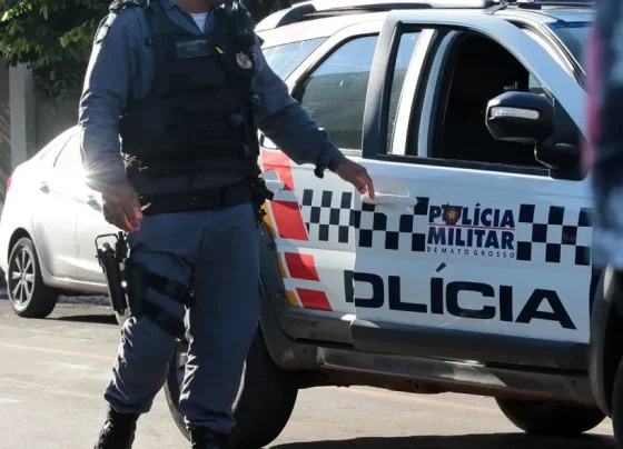 Foto de PM ao lado de viatura