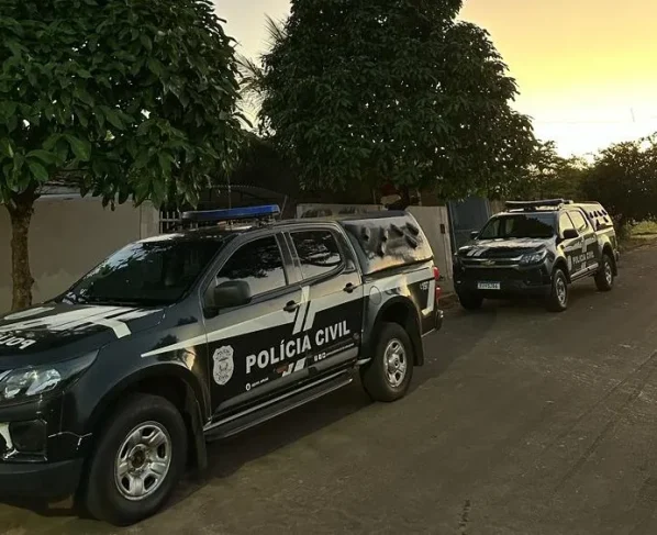 Viaturas da Polícia Civil estacionadas ao lado de árvores