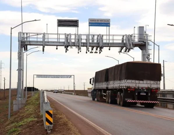 Pórtico eletrônico de pedágio free flow com câmeras de leitura de placas instalado sobre rodovia asfaltada em Mato Grosso