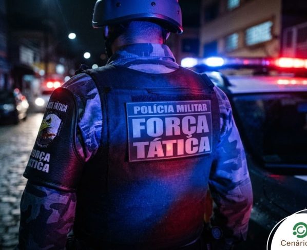 Policial militar da força tática ao lado de viatura