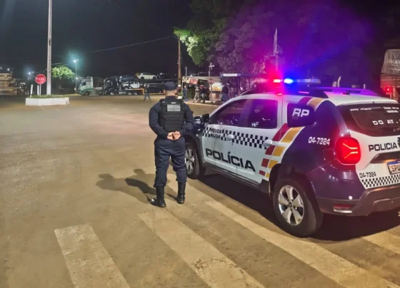 Policial militar ao lado de viatura